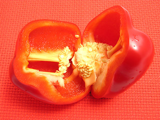 Image showing Red pepper cutted into halves on a red placemat