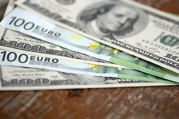 Image showing packs of dollars and euro money on wooden background