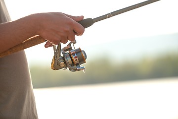 Image showing Modern clean fishing rod in hands