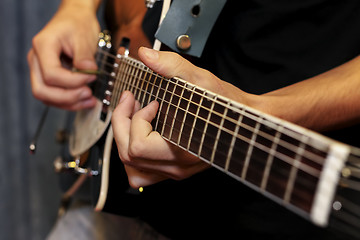 Image showing electric guitar close-up with fingers playing it