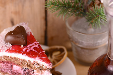 Image showing pieces of cake on wooden background with flowers and carafe