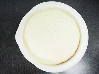 Image showing Proven dough in a white plastic bowl on black table