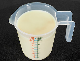Image showing Half a liter of white milk in a transparent measurement plastic 