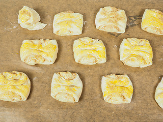 Image showing Plaited cinnamon rolls on baking paper with egg wash