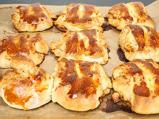 Image showing Fresh made cinnamon buns plaited on baking paper