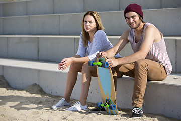 Image showing Young skateboarding couple on a beach