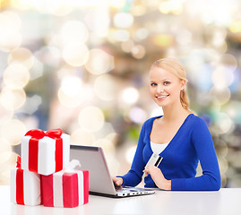 Image showing smiling woman with credit card and laptop