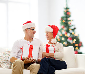 Image showing happy senior couple in santa hats with gift boxes