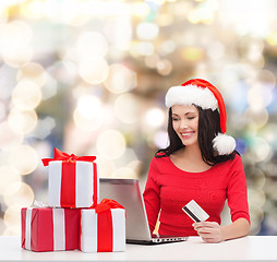 Image showing smiling woman with gifts, laptop and credit card