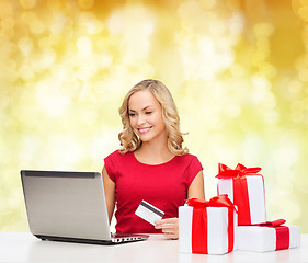 Image showing smiling woman with credit card and laptop