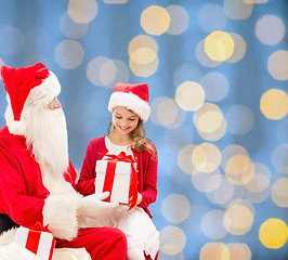 Image showing smiling little girl with santa claus and gifts