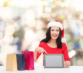 Image showing smiling woman in santa hat with bags and tablet pc