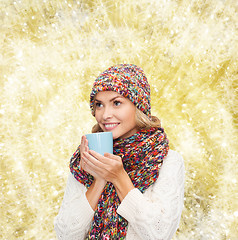 Image showing smiling young woman in winter clothes with cup