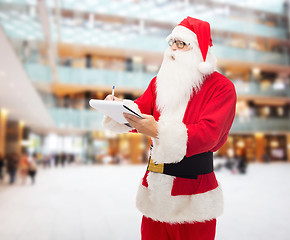 Image showing man in costume of santa claus with notepad