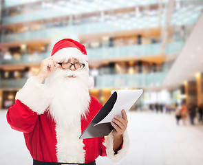 Image showing man in costume of santa claus with notepad