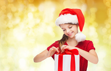 Image showing smiling girl in santa helper hat with gift box