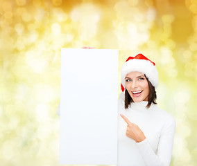 Image showing smiling young woman in santa hat with white board