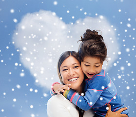 Image showing smiling little girl and mother hugging indoors