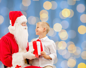 Image showing smiling little boy with santa claus and gifts