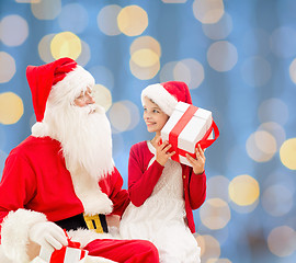 Image showing smiling little girl with santa claus and gifts