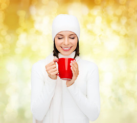 Image showing smiling young woman in winter clothes with cup