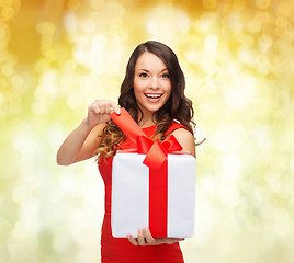 Image showing smiling woman in red dress with gift boxes