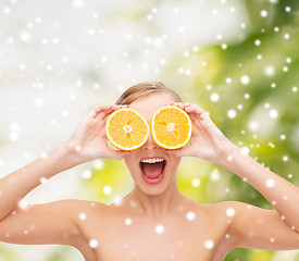 Image showing amazed young woman with orange slices