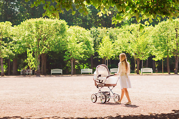 Image showing happy mother with stroller in park