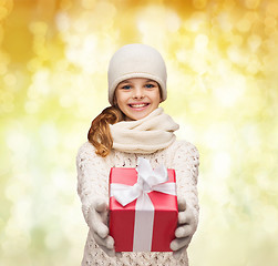 Image showing dreaming girl in winter clothes with gift box