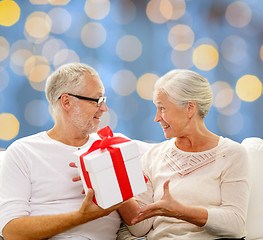 Image showing happy senior couple with gift box