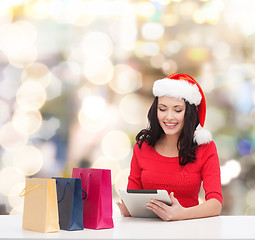 Image showing smiling woman with shopping bags and tablet pc