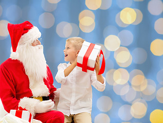 Image showing smiling little boy with santa claus and gifts