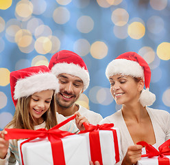 Image showing happy family in santa helper hats with gift boxes