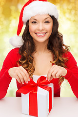 Image showing smiling woman in santa helper hat with gift box