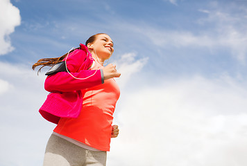 Image showing smiling young woman running outdoors