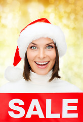 Image showing smiling woman in santa helper hat with sale sign