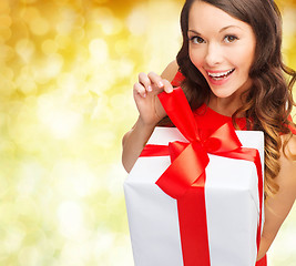 Image showing smiling woman in red dress with gift box