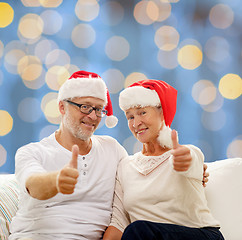 Image showing happy senior couple in santa helper hats