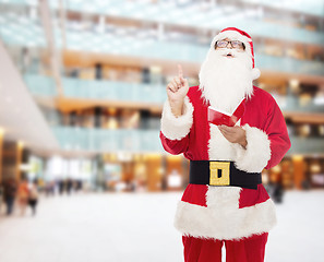 Image showing man in costume of santa claus with notepad