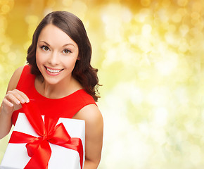 Image showing smiling woman in red dress with gift box