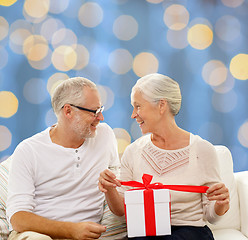 Image showing happy senior couple with gift box