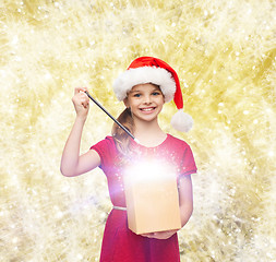 Image showing smiling girl in santa helper hat with gift box