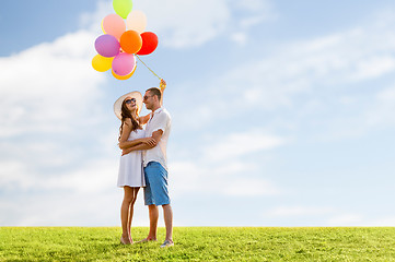 Image showing smiling couple with air balloons outdoors