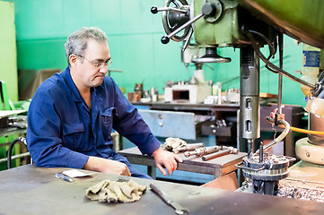 Image showing Senior milling machine operator works at machine