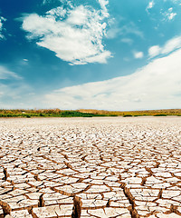 Image showing dramatic sky with clouds over cracked desert