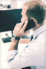 Image showing businessman with smartphone in office