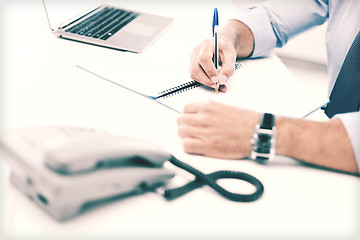 Image showing businessman writing in notebook