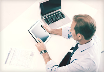 Image showing businessman with tablet pc and papers in office