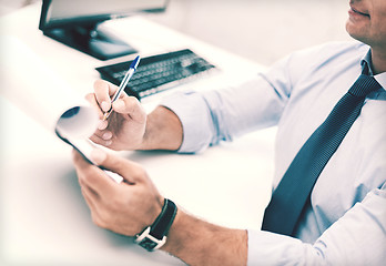 Image showing businessman working and signing papers