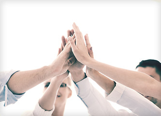Image showing happy business team giving high five in office